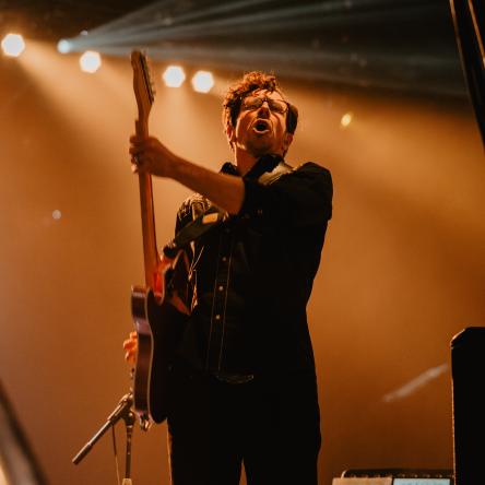 Tom Billington plays guitar at a YV concert